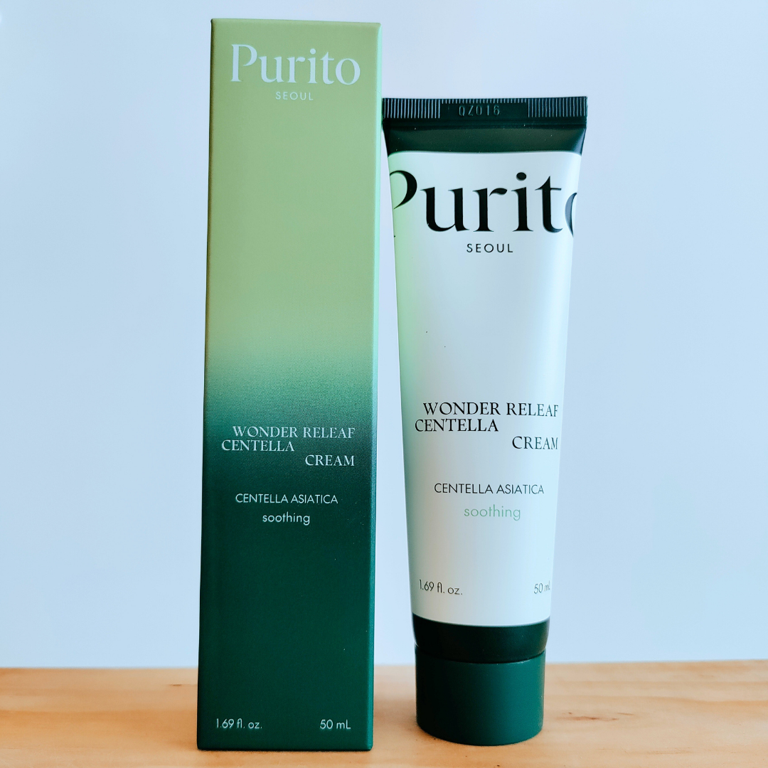 Purito Wonder Release Centella Cream packaging on a wooden surface with a light blue background