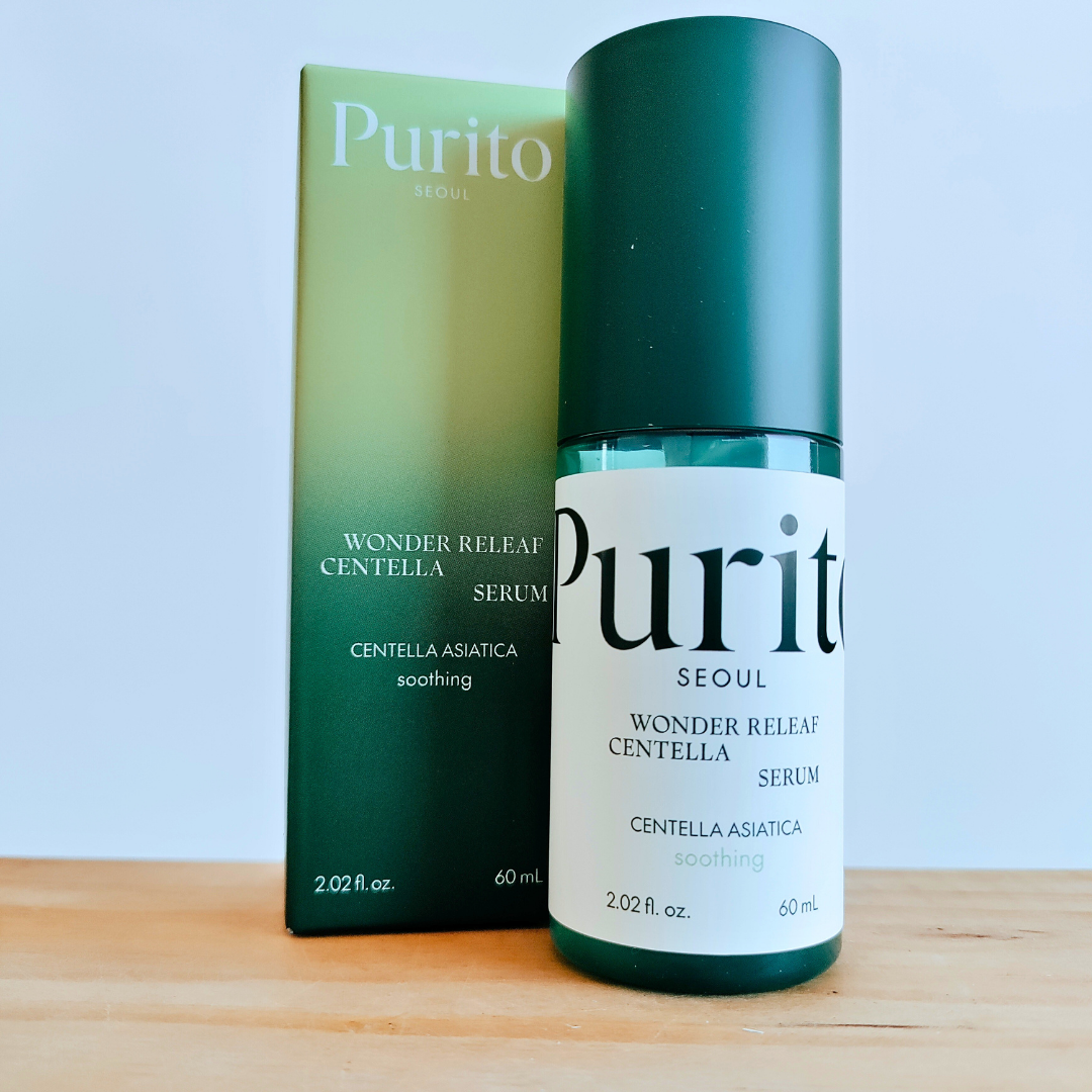 Purito Seoul Wonder Relief Centella Serum bottle and packaging on a wooden surface with a light blue background