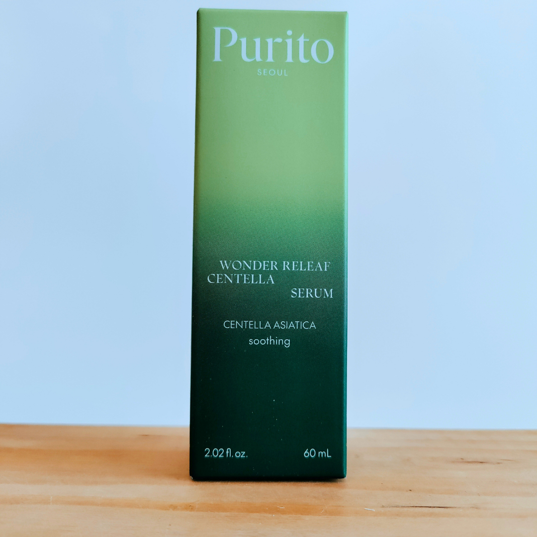 Purito Wonder Releaf Centella Serum box on a wooden surface with a light blue background